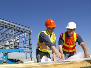 due operai consultano un progetto in un cantiere