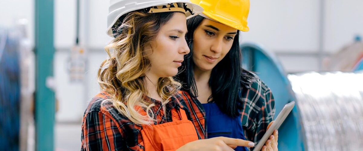 due donne con casco di protezione consultano tablet