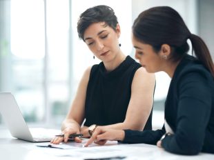 due donne consultano brochure durante un meeting