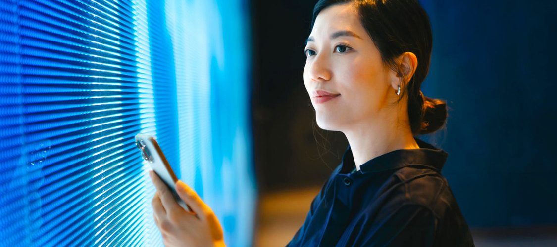 ragazza con smartphone controlla dati su digital screen