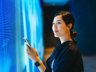 ragazza con smartphone controlla dati su digital screen