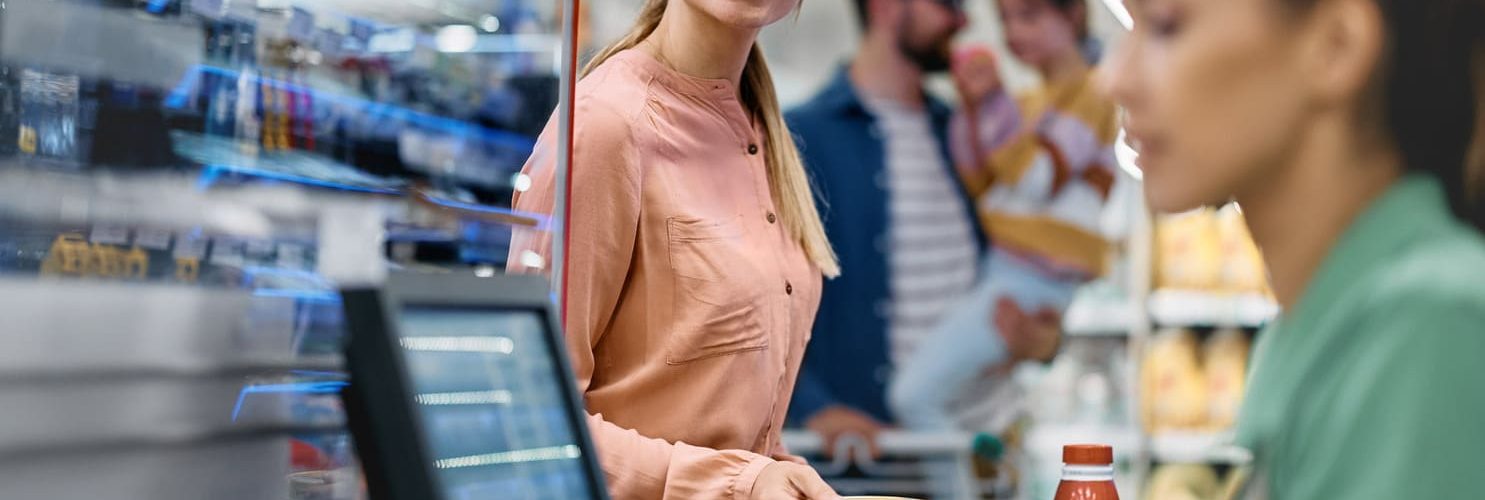persona paga in cassa al supermercato