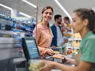 persona paga in cassa al supermercato