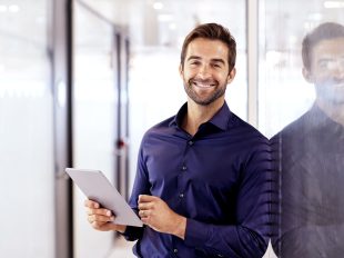 persona sorridente consulta tablet all'interno di un ufficio