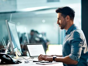 giovane uomo con camicia inserisce dati all'interno di un software
