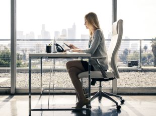 ragazza bionda consulta smartphone seduta sulla scrivania