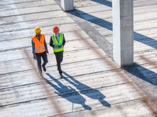 due persone camminano in un cantiere