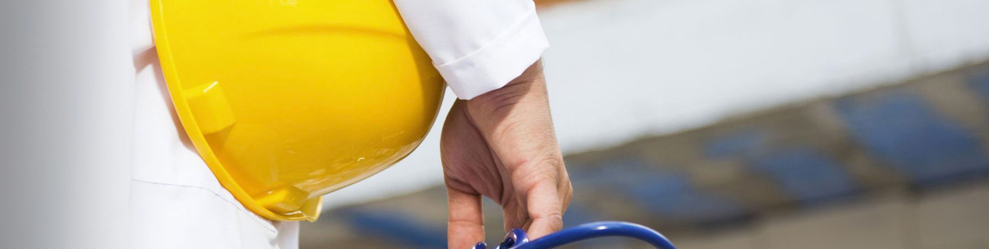 persona con camice da medico tiene in mano un casco di sicurezza