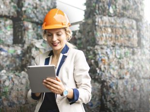 donna con casco di sicurezza consulta tablet