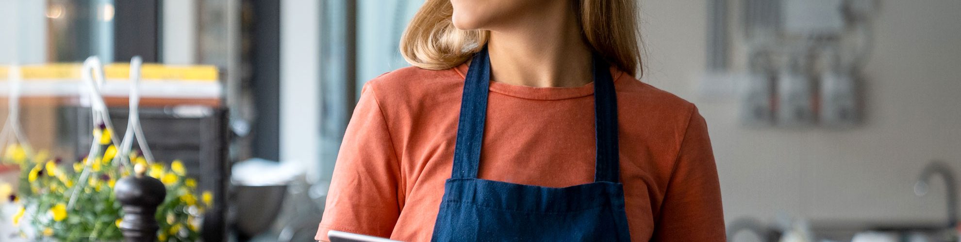 ragazza con grembiule sorridente in un ristorante